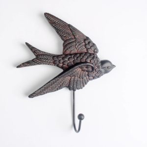 Rustic cast iron swallow wall hook with distressed black-and-copper finish, vintage bird design, and sturdy metal hook for hanging keys, coats, and towels.