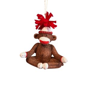 1. Festive ceramic sock monkey ornament sitting in yoga pose, wearing a red Christmas hat with wool pom-pom and hanging from jute thread