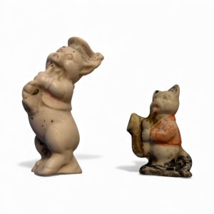 Vintage Japanese bisque pig and cat figurines from the 1950s, each playing a horn instrument, used as Animal Band cake toppers.