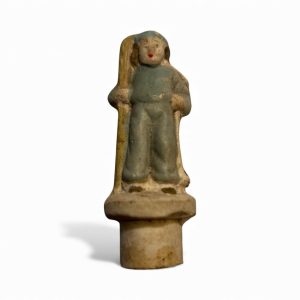 Small 1950s Japanese bisque skier figurine with blue outfit, skis on shoulder, and hand-painted details.