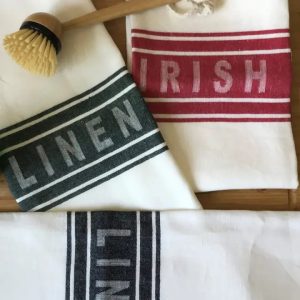 Pair of traditional Irish linen tea towels with coloured centre band, available in black, red, or green, made from 100% flax linen.