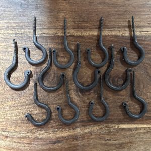 Set of twelve rustic hand-forged iron ceiling hooks with black wax finish and assorted handmade variations. Slightly wonky.